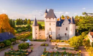 Le château du Rivau, propriété de la famille, s'illumine sous le soleil d'automne, entouré de jardins colorés.