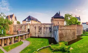 Le majestueux **Château de Nantes** se dresse fièrement, entouré de douves verdoyantes et d'une pelouse impeccable. Un pont mène à son entrée fortifiée.