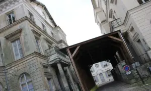 Passage couvert menant au palais du roi de Rome, avec des bâtiments anciens et une cour pavée.