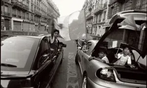 Enfants agitant des drapeaux français dans des voitures, une scène évoquant le droit du sol sous Mitterrand.