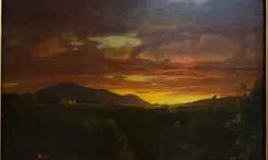 Un paysage de crépuscule, baigné de lumières orangées et dorées, évoquant la beauté mélancolique d'un crépuscule victor hugo. Des montagnes se dressent à l'horizon, tandis que des lumières douces émanent de quelques habitations.