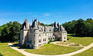 Magnifique chateau dans le Cher, avec ses tours et son parc verdoyant sous un ciel bleu.
