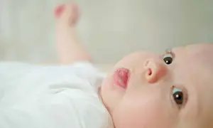 Un bébé aux yeux curieux sort sa langue, un geste innocent dont la signification peut varier.