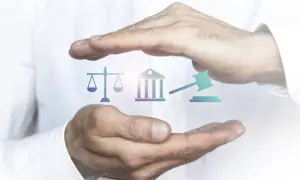 Mains protégeant des icônes symbolisant la justice : balance, bâtiment de tribunal, marteau de juge. L'image évoque l'importance de l'état de droit.