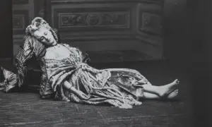 La comtesse de Castiglione, vêtue d'une robe somptueuse, repose, le visage serein, sur un sol en bois.
