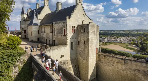 Visiteurs sur le pont menant au château de Chinon. Renseignez-vous sur le château de Chinon tarif pour votre visite.
