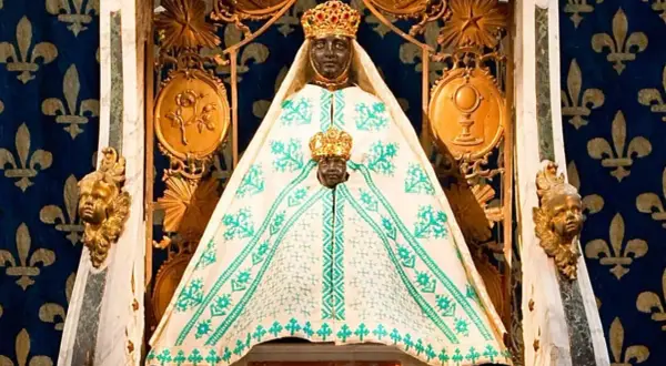 Statue de la Vierge noire couronnée, entourée de symboles religieux. Une image qui raconte une partie de l'histoire de la vierge noire.