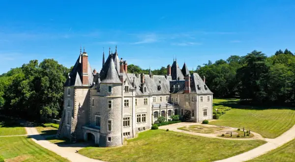 Magnifique chateau dans le Cher, avec ses tours et son parc verdoyant sous un ciel bleu.