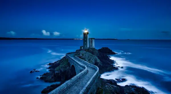 Un phare solitaire, tel un gardien des mers, éclaire la nuit. Son faisceau puissant guide les navires, rappelant les vers de Baudelaire sur la beauté sombre de l'océan.