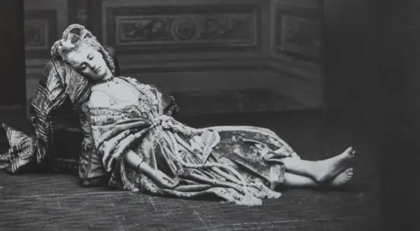 La comtesse de Castiglione, vêtue d'une robe somptueuse, repose, le visage serein, sur un sol en bois.