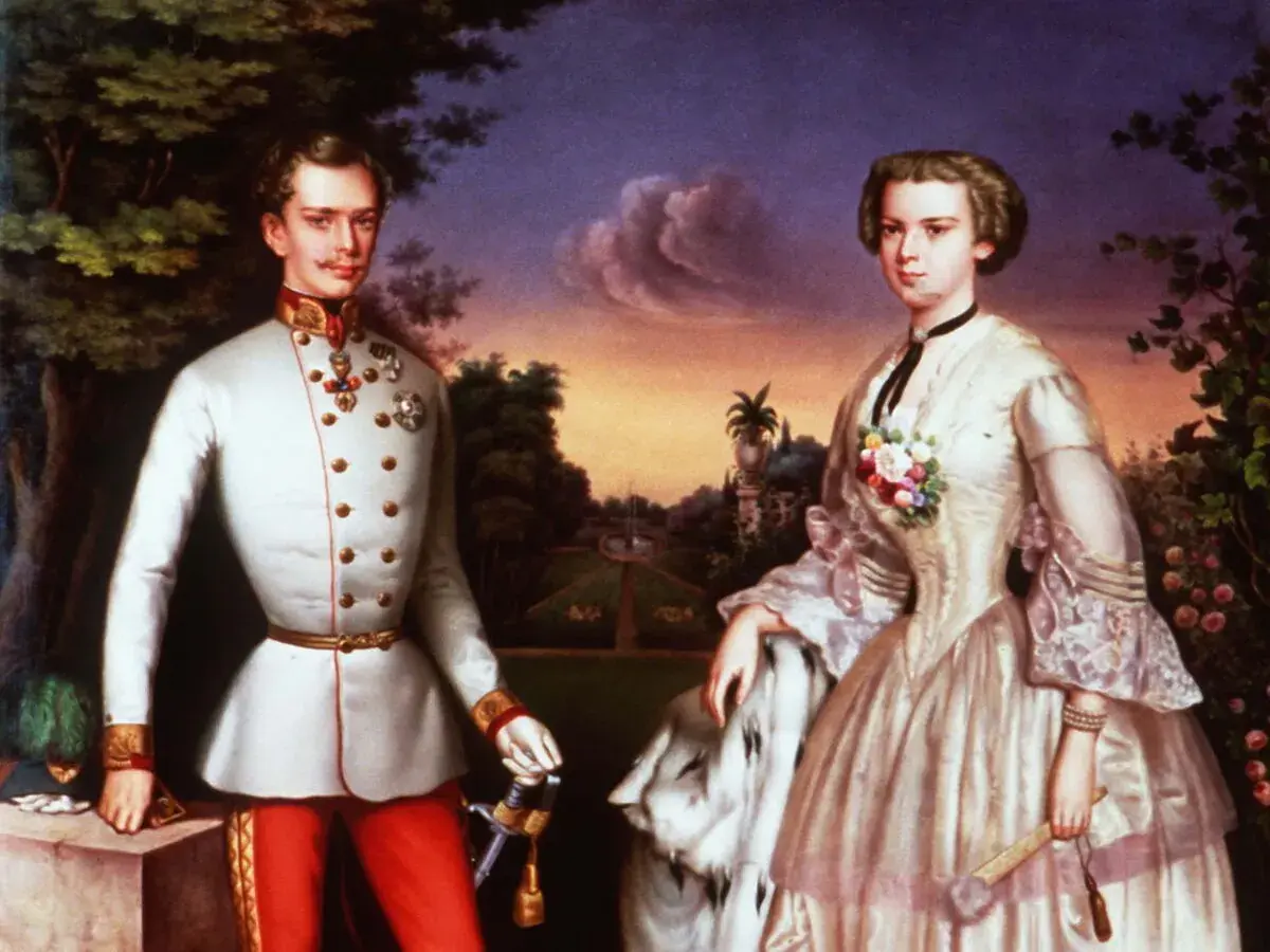 Sissi et Maximilien, frère de Franz, posent dans un jardin. Elle porte une robe élégante, lui un uniforme militaire.