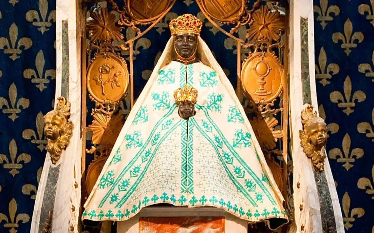 Statue de la Vierge noire couronnée, entourée de symboles religieux. Une image qui raconte une partie de l'histoire de la vierge noire.