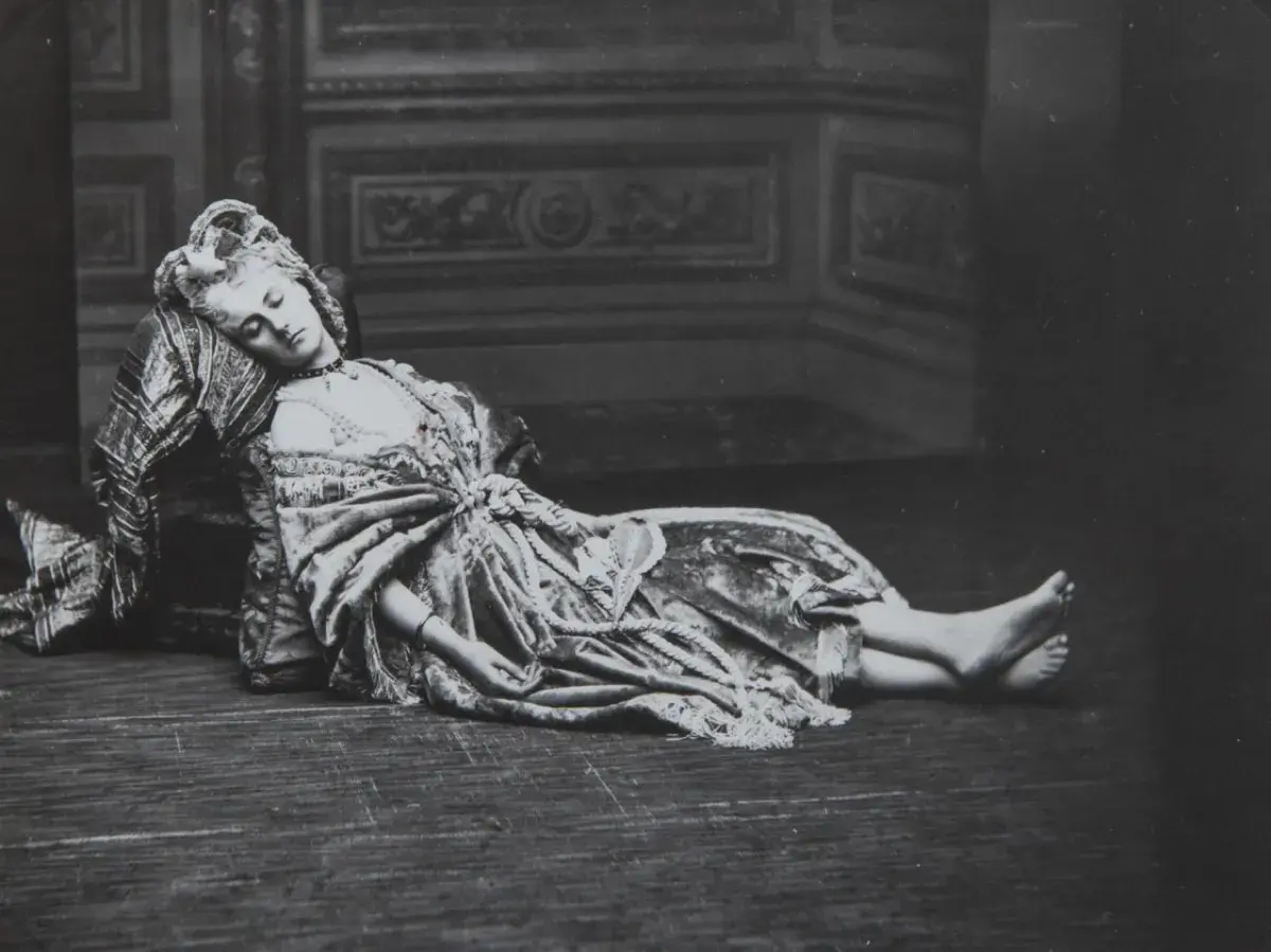 La comtesse de Castiglione, vêtue d'une robe somptueuse, repose, le visage serein, sur un sol en bois.