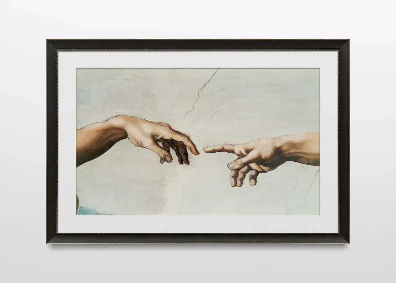 Le tableau encadr&eacute; montre la c&eacute;l&egrave;bre fresque de Michel-Ange, La Cr&eacute;ation d'Adam. Les mains de Dieu et d'Adam se tendent l'une vers l'autre, symbolisant la transmission de la vie. La signification des mains de Michel-Ange est profonde.