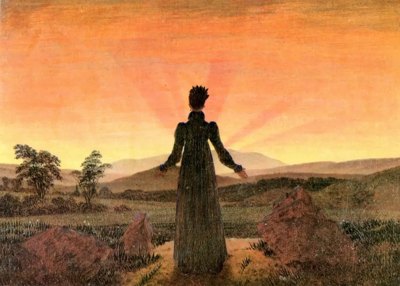 Une silhouette se tient face &agrave; un soleil couchant victor hugo, bras ouverts, dans un paysage de collines et de rochers.