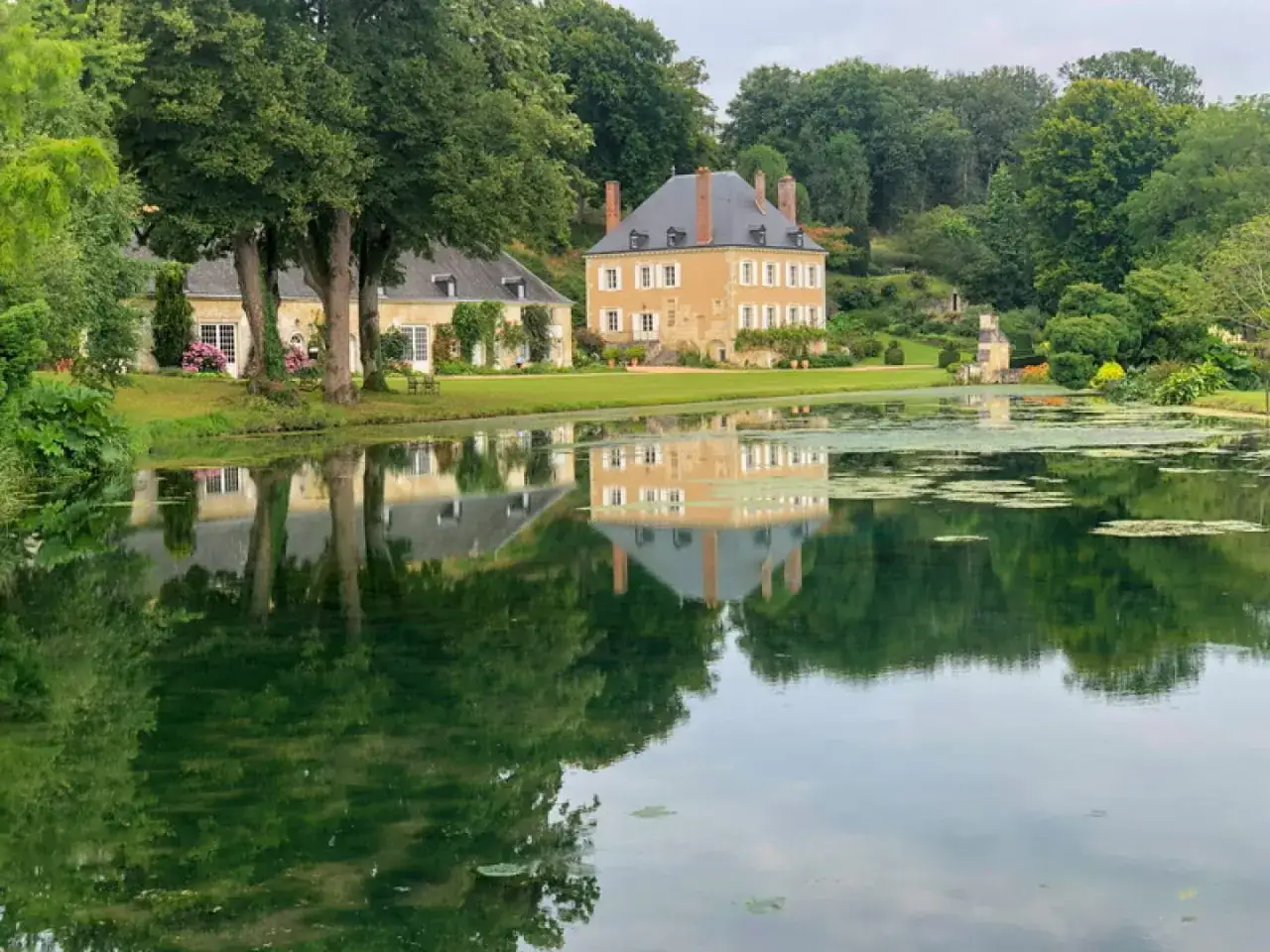 Le jardin du Plessis Sasni&egrave;res, avec son &eacute;tang paisible refl&eacute;tant le ch&acirc;teau et la verdure luxuriante, invite &agrave; la contemplation.
