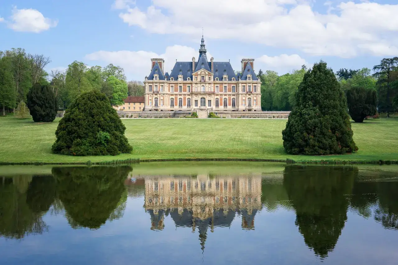 Magnifique ch&acirc;teau en Eure-et-Loir, refl&eacute;t&eacute; dans un &eacute;tang paisible, entour&eacute; de verdure et d'arbres majestueux.