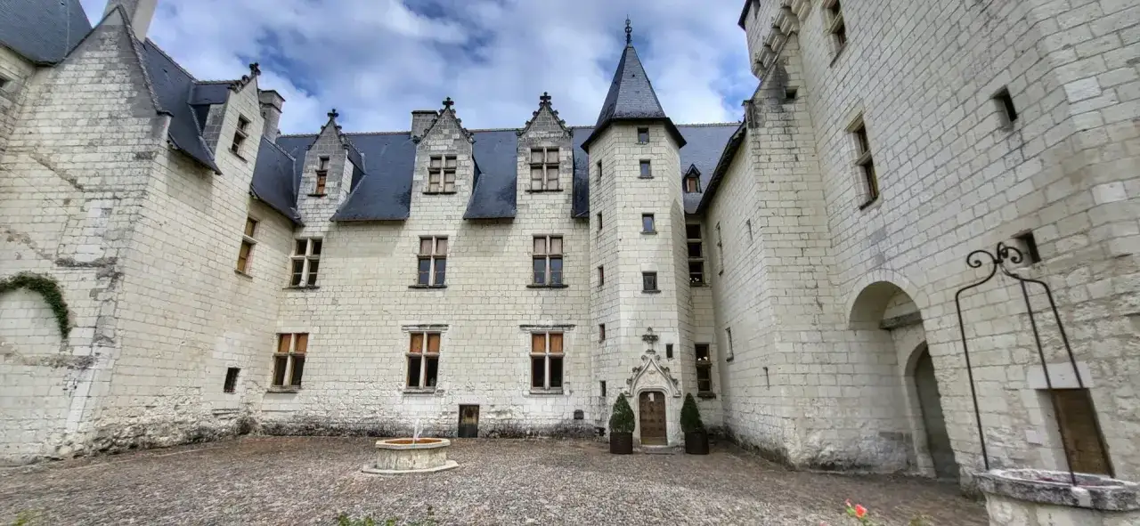 Cour int&eacute;rieure du ch&acirc;teau du Rivau, avec sa fa&ccedil;ade en pierre blanche, ses toits d'ardoise et sa fontaine. Le propri&eacute;taire a su pr&eacute;server l'authenticit&eacute; du lieu.