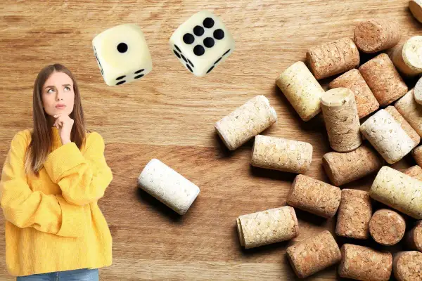 Une jeune femme réfléchit devant des dés et une pile de bouchons. Elle semble hésiter avant de commencer un jeu du bouchon.