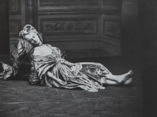 La comtesse de Castiglione, vêtue d'une robe somptueuse, repose, le visage serein, sur un sol en bois.